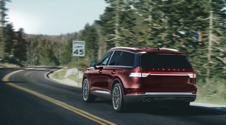A 2024 Lincoln Aviator® SUV is being driven on a winding mountain road | Rogers Lincoln in Midland TX